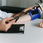 a healthcare worker measuring a patient s blood pressure using a sphygmomanometer